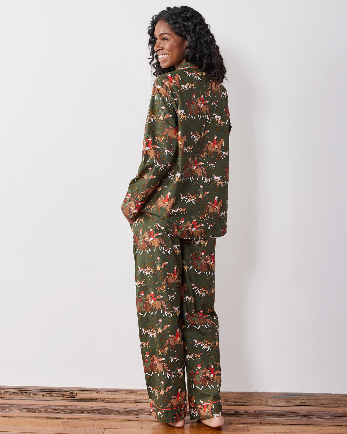 Back three-quarter view of a model wearing the Fox & Hounds long pajama set with matching printed top and pants.