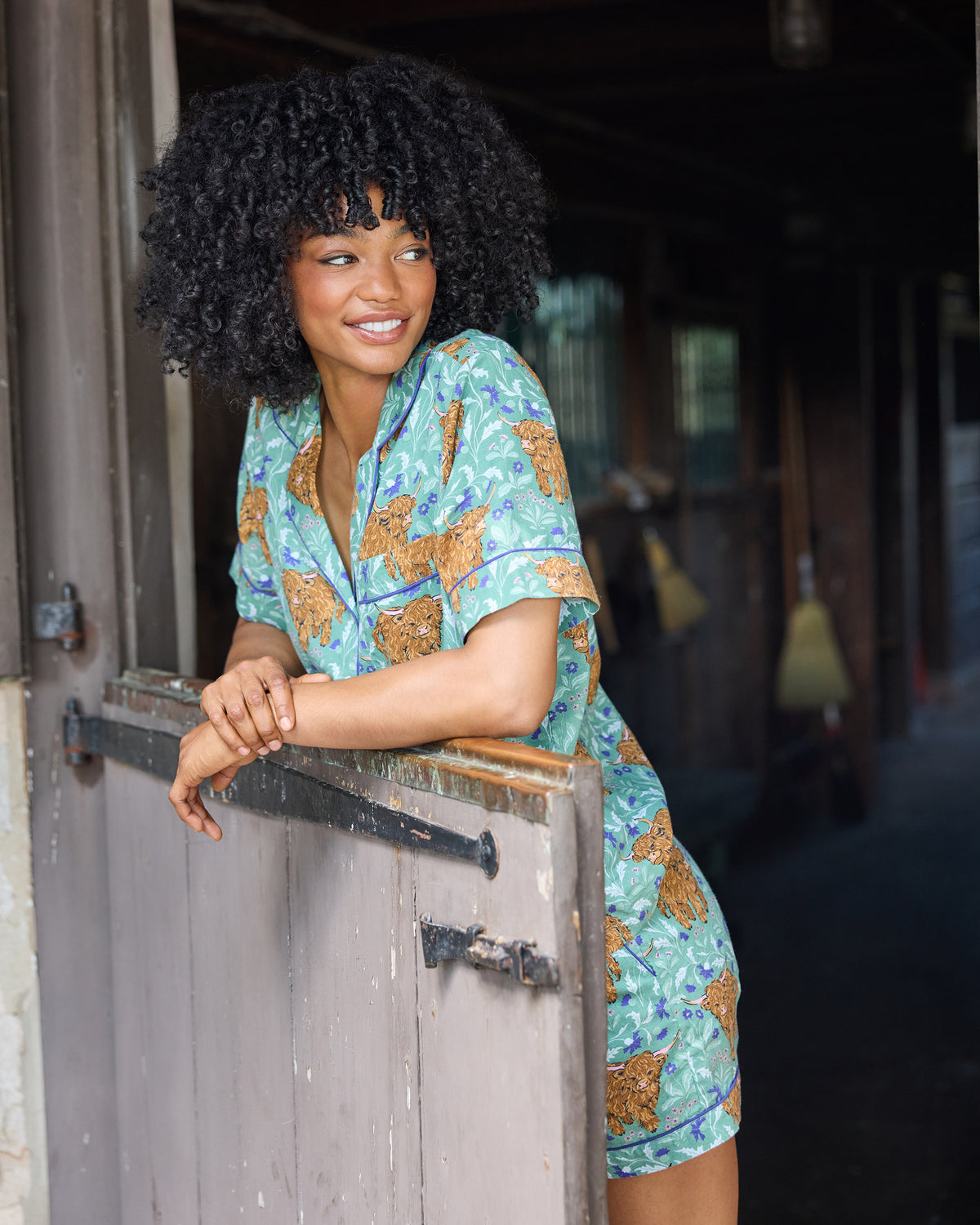 Person wearing the Soft Thistle Highland Cows short pajama set while leaning on a doorway.