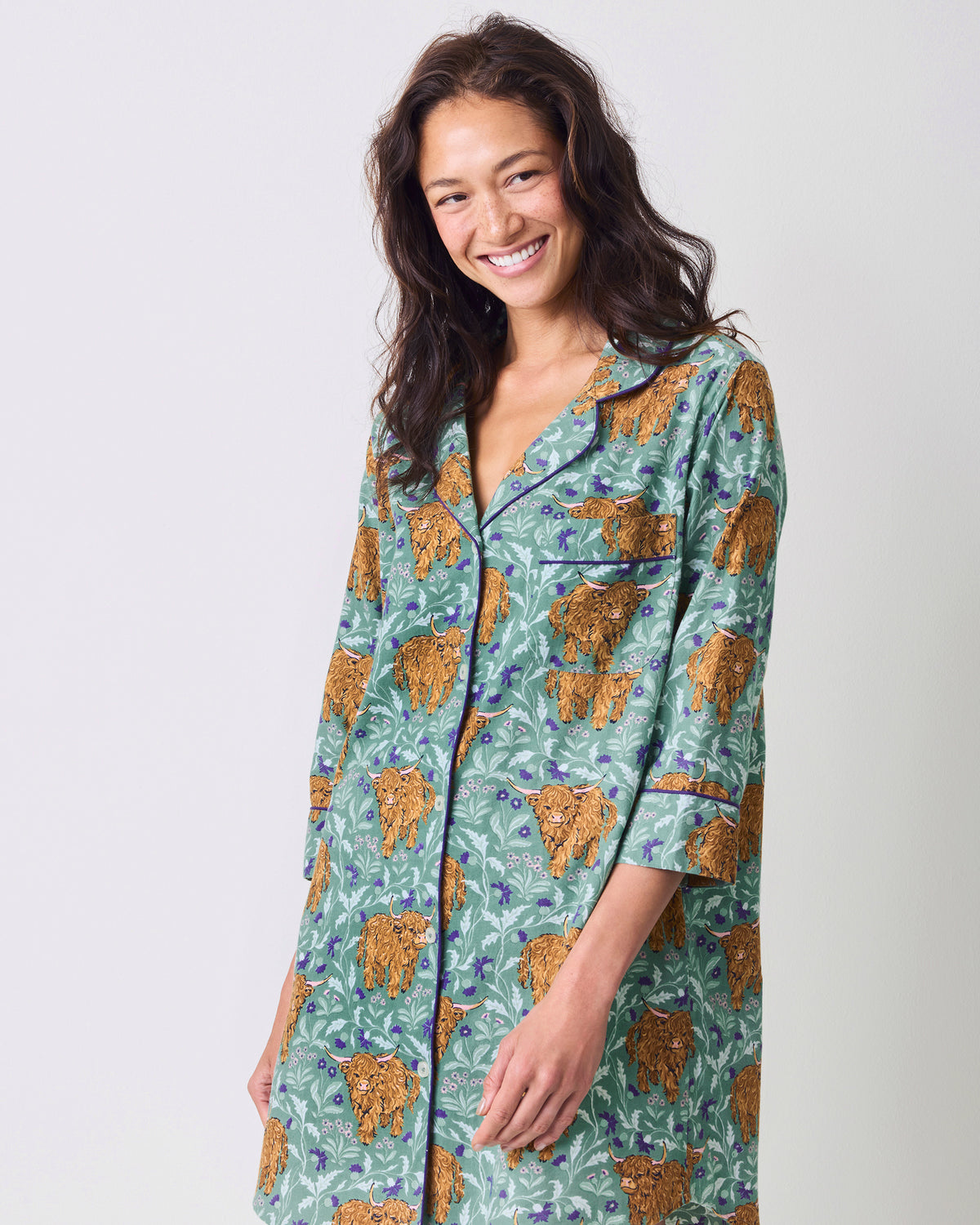 Model wearing a green Highland cow-print button-down sleep shirt with three-quarter sleeves.