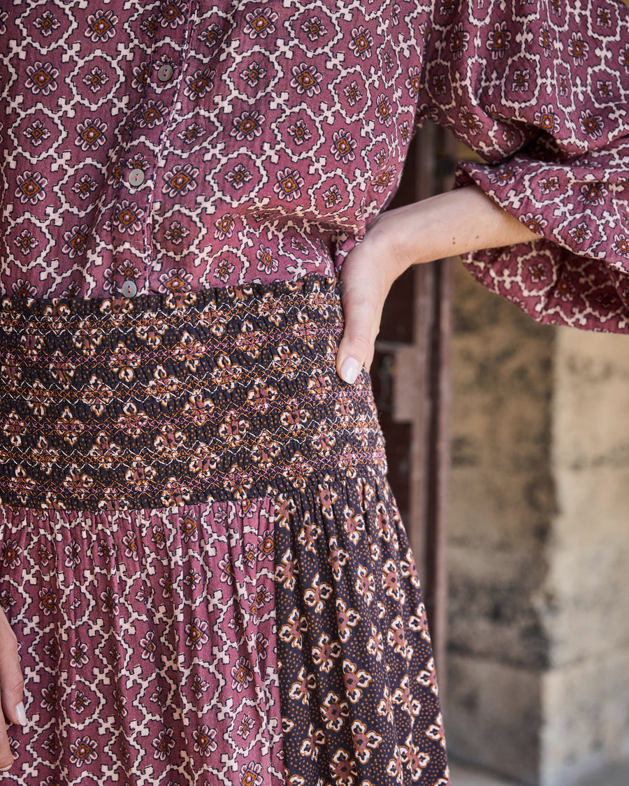 Detail view of the patterned blouse button front above the Coraline skirt’s gathered contrasting waistband.