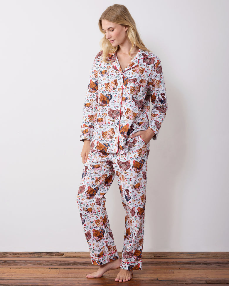 Model wearing a long-sleeve button-front pajama top and matching pants with hands in the top pockets.
