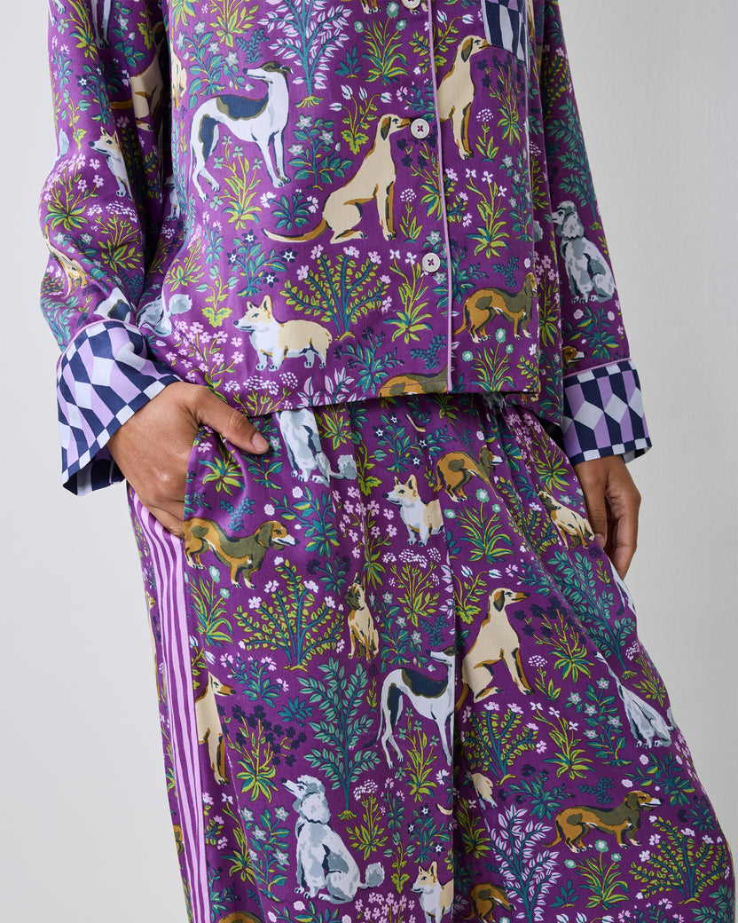 Close view of a purple dog-print pajama shirt and wide-leg pants with checkerboard cuffs.