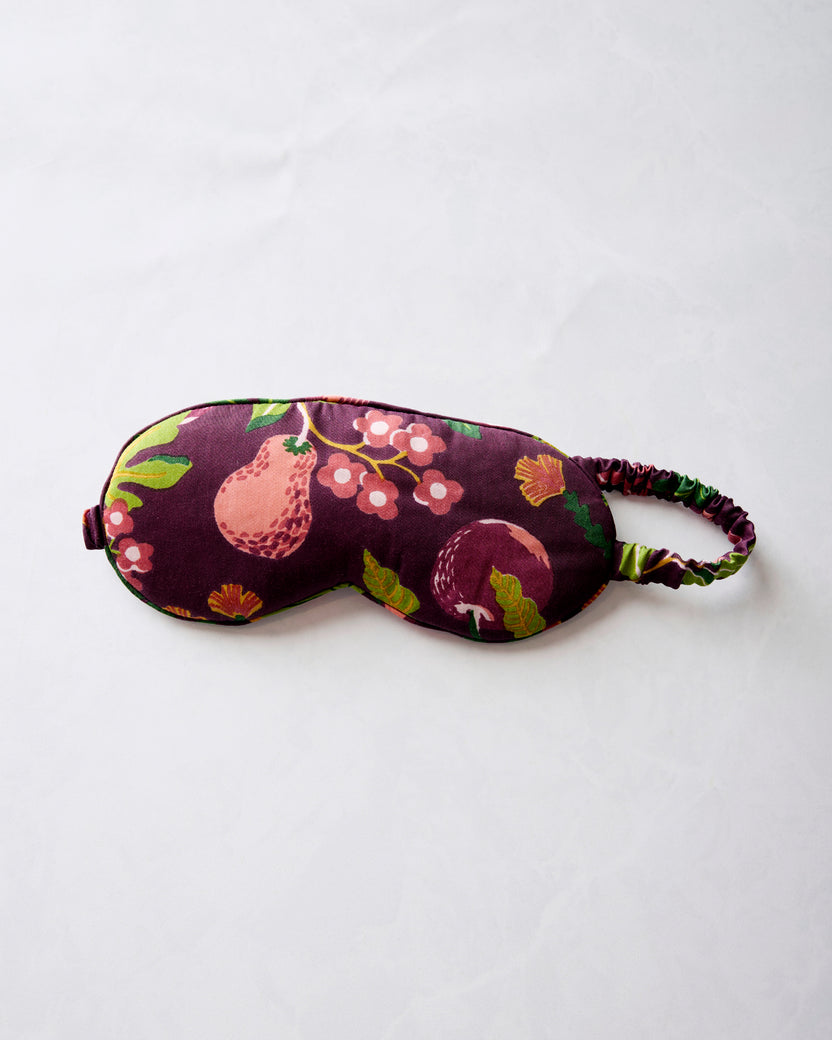 Plum Pomme & Poire fruit-print eye mask with an adjustable elastic strap, laid flat.