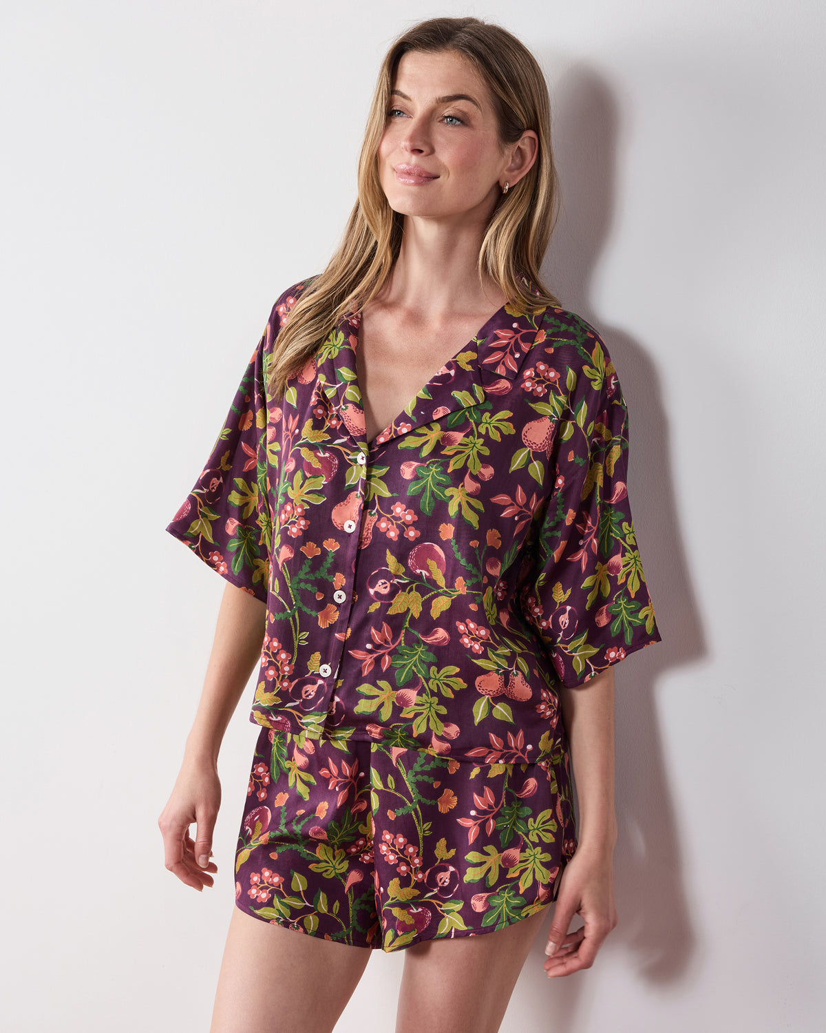 Front view of the plum Pomme & Poire Sweet Dreams short pajama set with a button-front top and fruit-and-floral print.