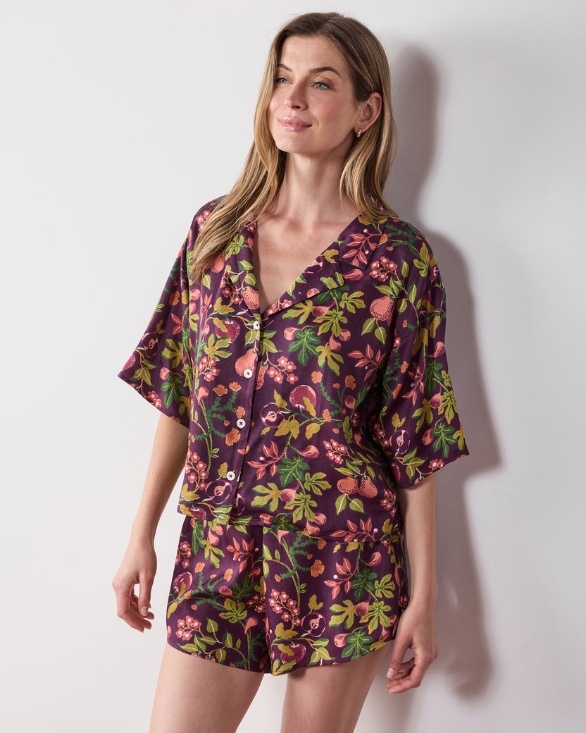 Front view of the plum Pomme & Poire Sweet Dreams short pajama set with a button-front top and fruit-and-floral print.