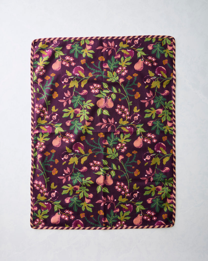 Pomme & Poire plum tea towel set of two, shown flat with a colorful fruit, floral, and leafy pattern.