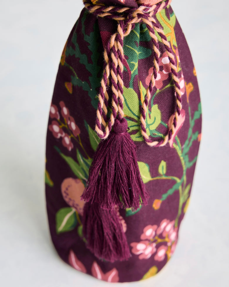 Close-up of the Pomme & Poire plum wine bag with braided wrap-around tie and two tassels.