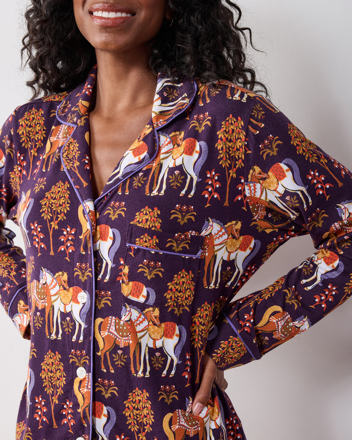 Front detail of the long-sleeve button-front pajama top with a chest pocket and horse-and-tree print.