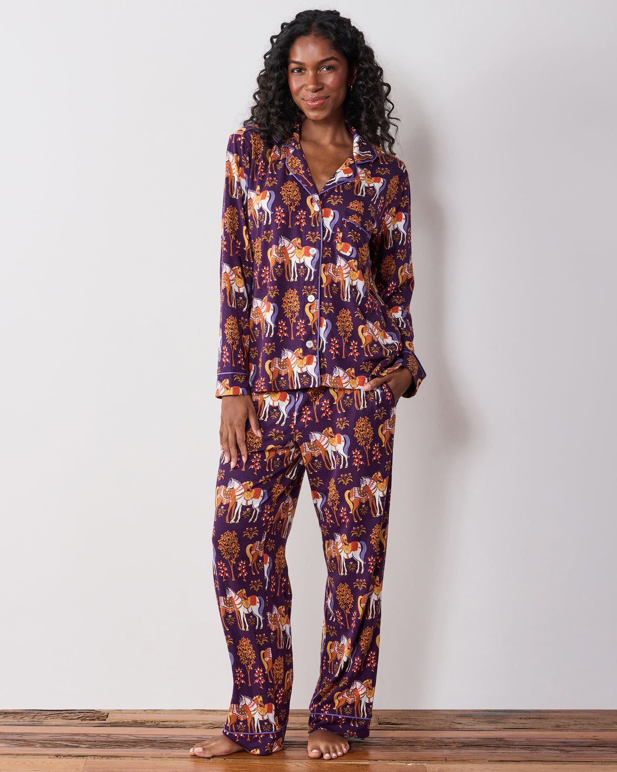 Front view of the long-sleeve pajama set with a collared button-front top and matching pants in a horse-and-tree print.