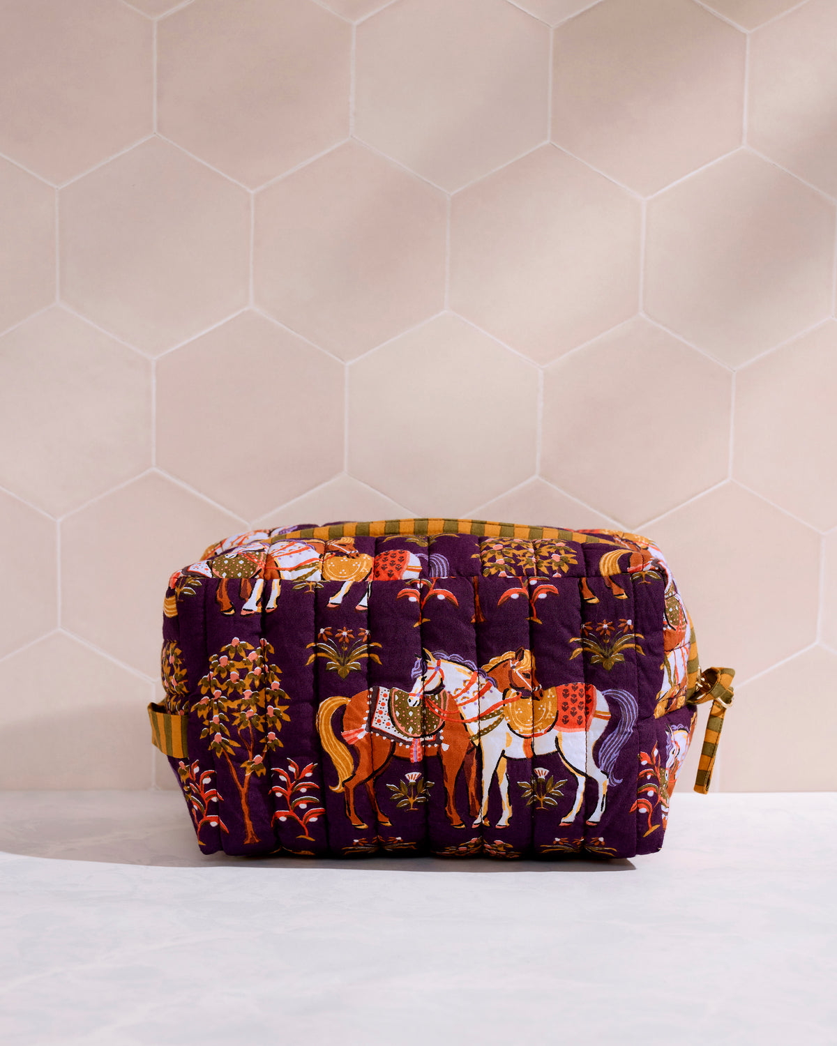 Quilted horse-print pouch shown closed on a bathroom counter.