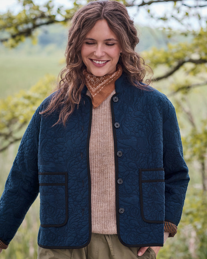 Front view of the vintage indigo Elliott jacket with quilted equestrian pattern, snap buttons, and two front patch pockets.