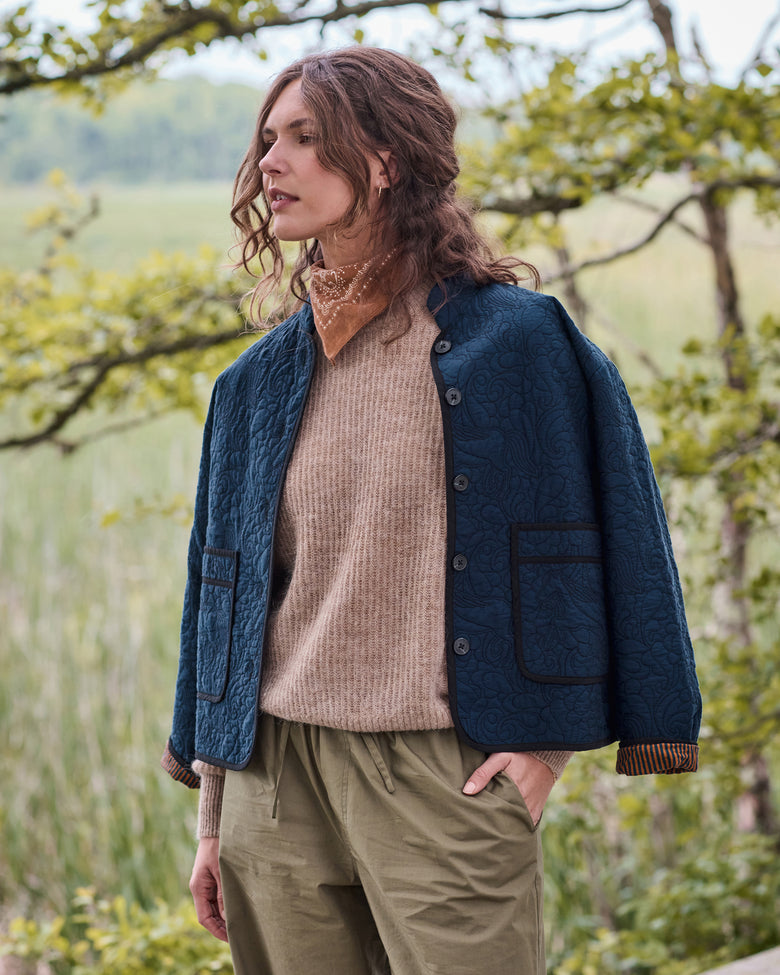 Front three-quarter view of the vintage indigo Elliott jacket with snap buttons, quilted pattern, and two large patch pockets.