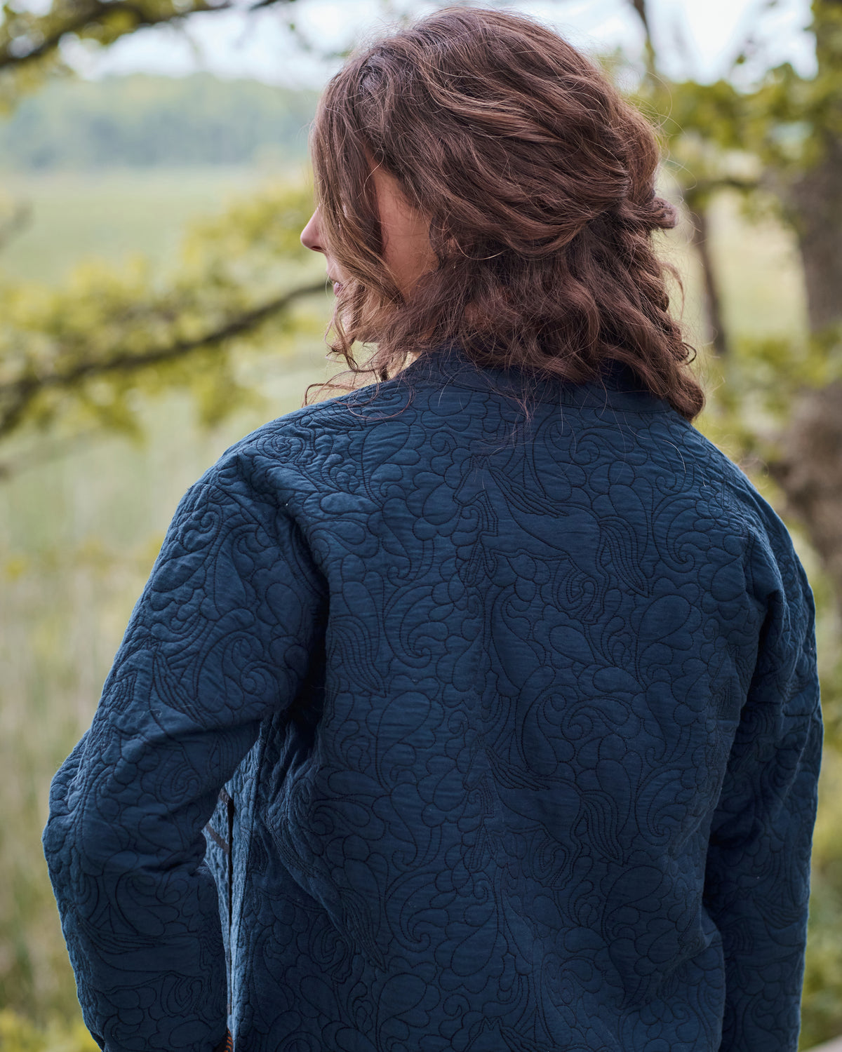 Back view of the vintage indigo Elliott jacket showing its full quilted equestrian pattern.