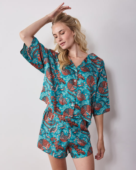 Front view of a teal patterned pajama set with a button-front top and shorts.