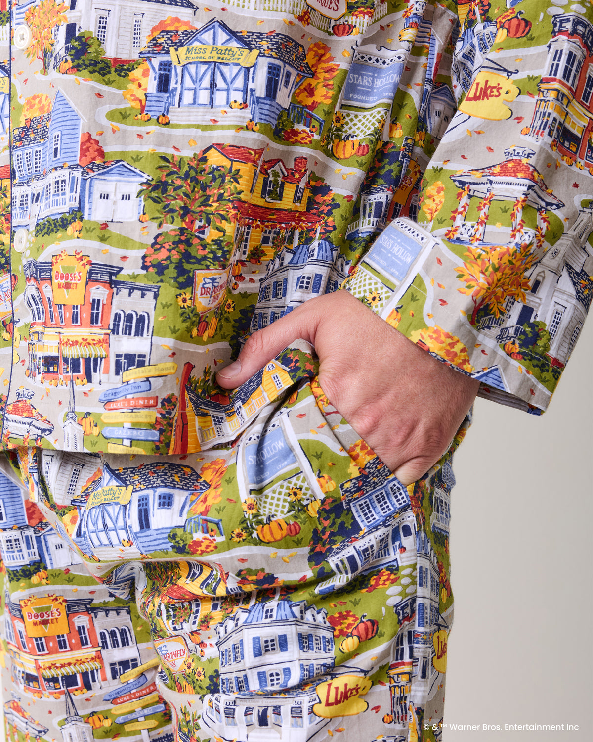 Close-up of the pajama shirt and pants showing the illustrated Stars Hollow town print and a side pocket.