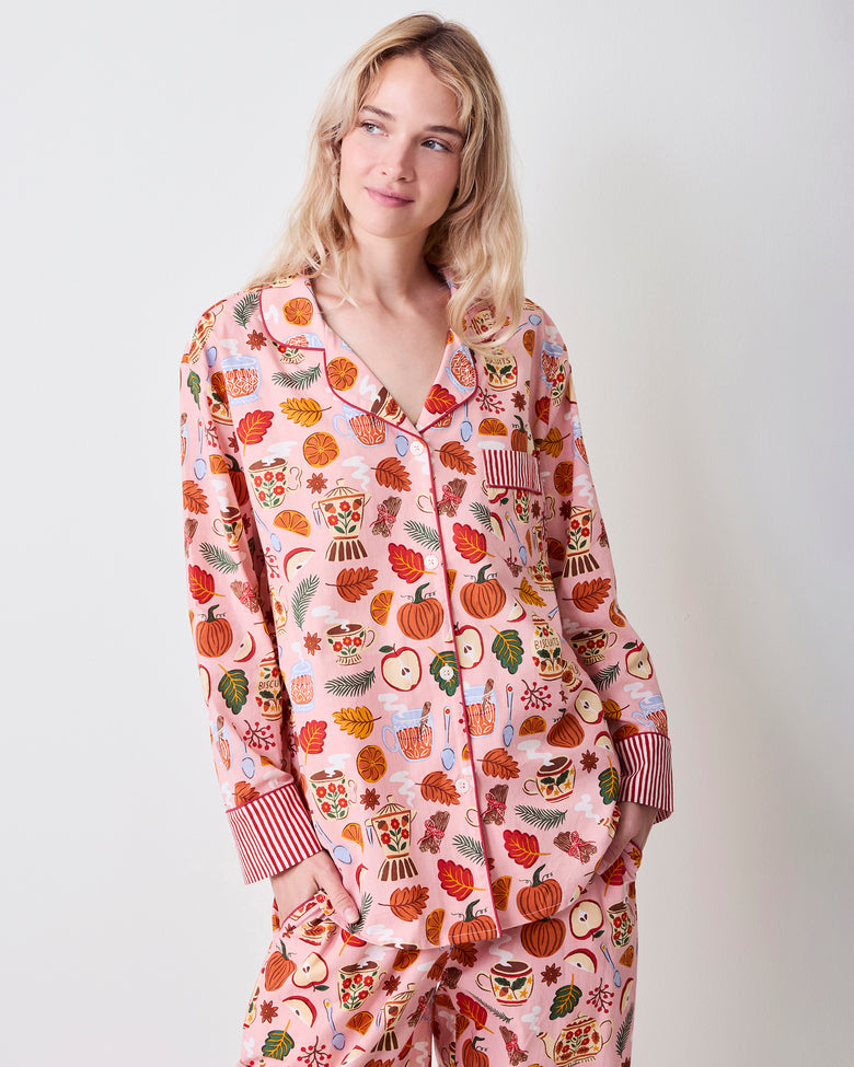 Front view of the pink Autumn Cafe long pajama set with notched collar, button-front top, chest pocket, striped cuffs, matching pants, and allover tea and autumn print.