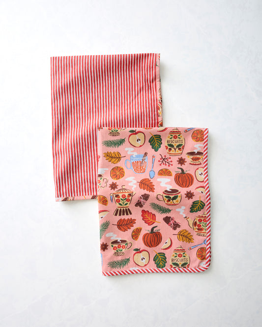 Two tea towels, one with red-and-white vertical stripes and one with a rose-pink autumn tea-and-kitchenware print.