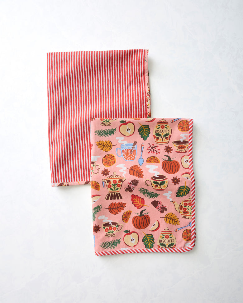 Two tea towels, one with red-and-white vertical stripes and one with a rose-pink autumn tea-and-kitchenware print.