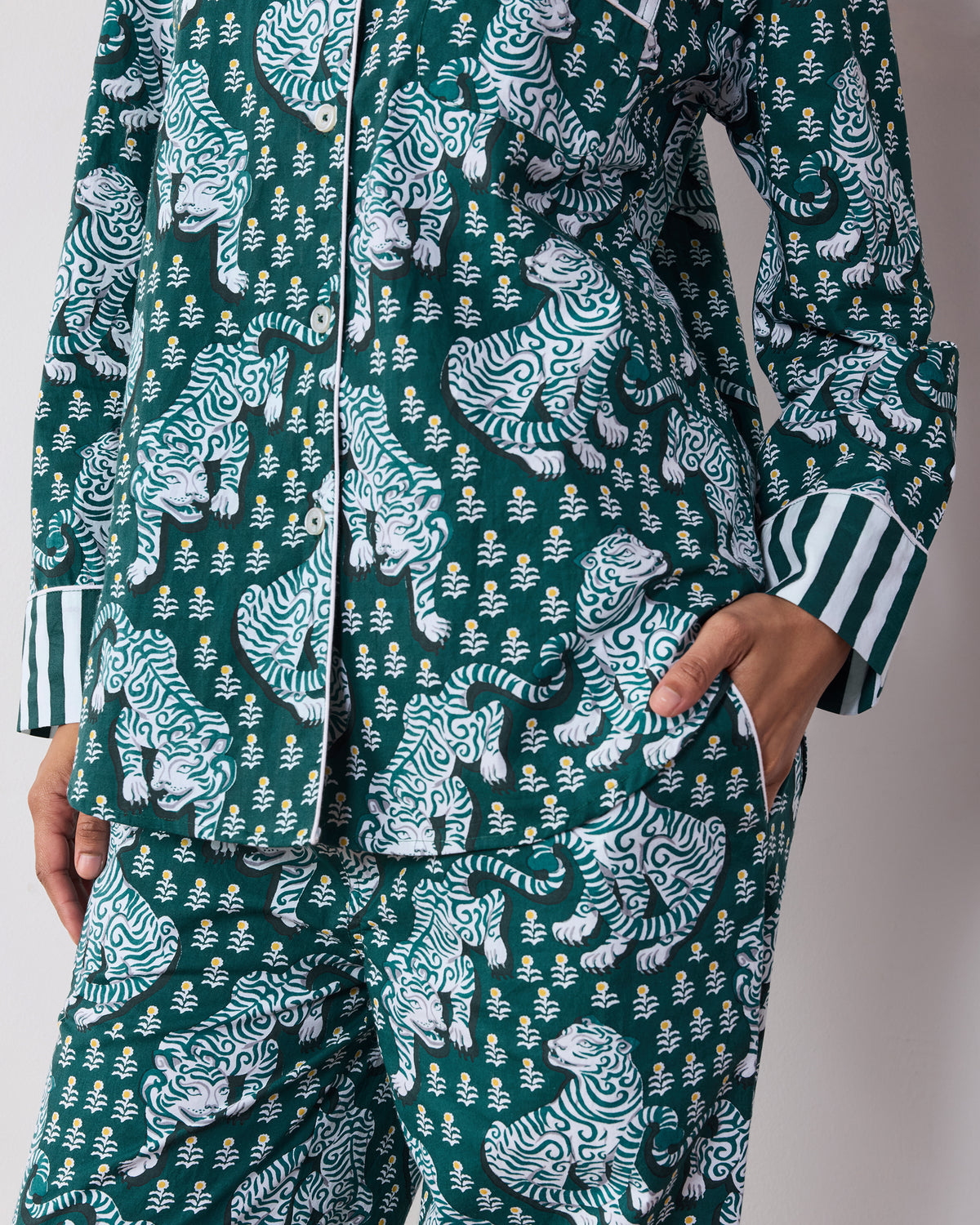 Close-up of the Game Day Green Tiger Queen pajama set showing the button front, chest and side pockets, striped cuff, tiger print, and matching pants.