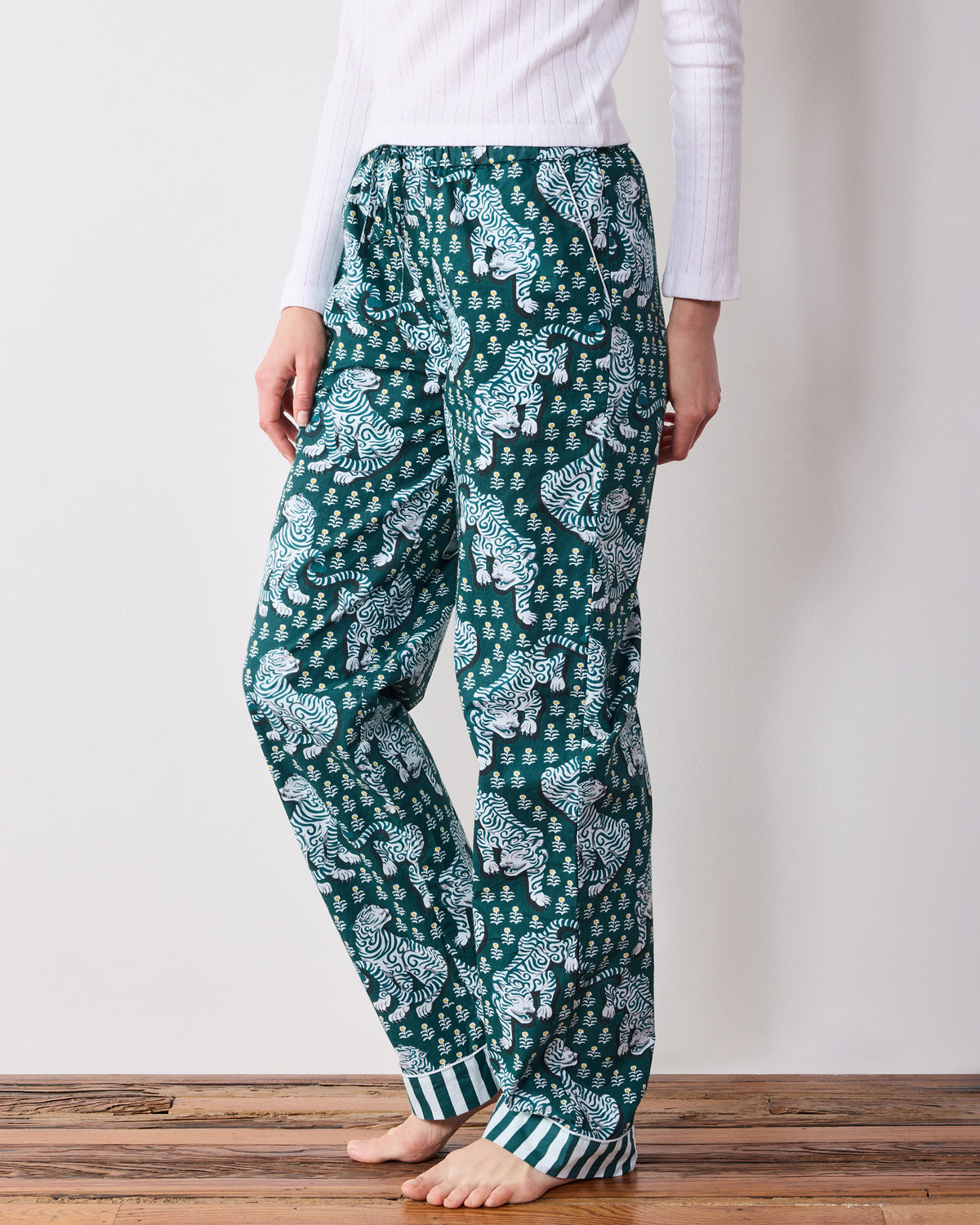 Side view of Game Day Green Tiger Queen petite pajama pants with an elastic drawstring waist, pockets, tiger print, and striped cuffs.