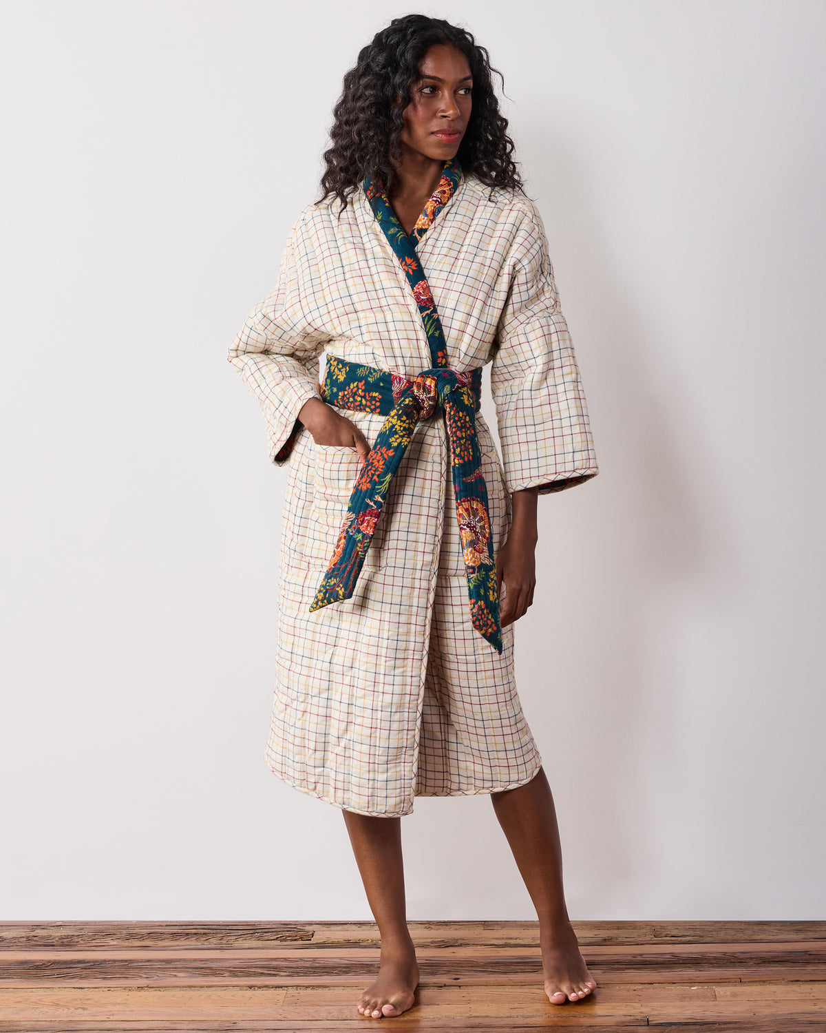 Front view of the reversible robe in its cream plaid side, with a navy printed collar, belt, trim, and front pockets.