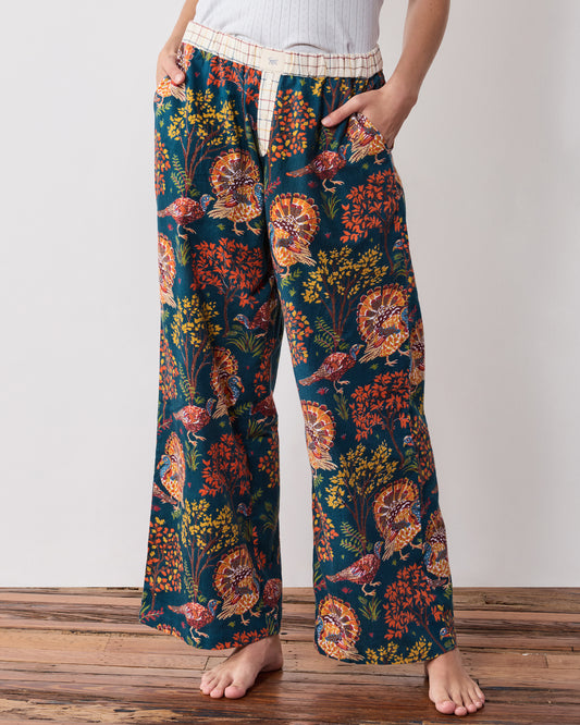 Close-up front view of the navy Turkey Trot pajama pants showing the contrasting waistband, button fly, pockets, and turkey print.
