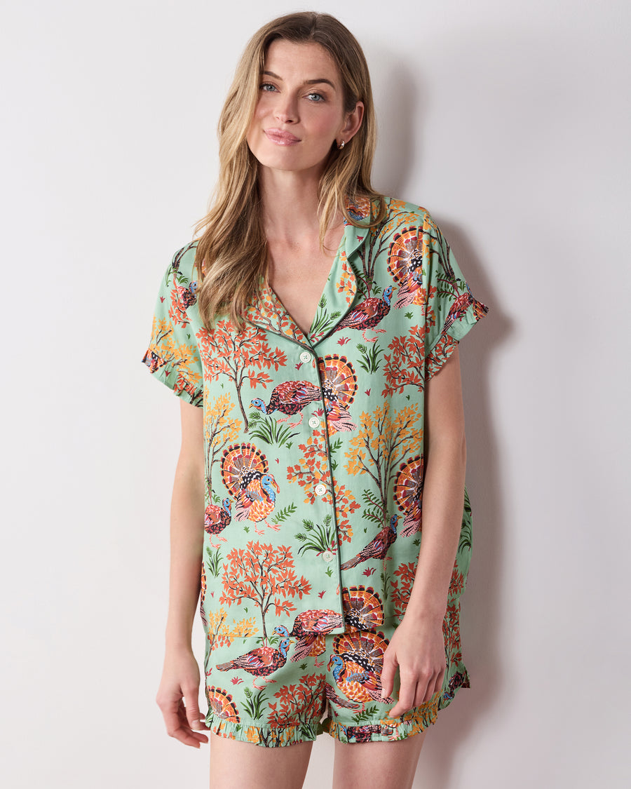 Front view of the Soft Sage Turkey Trot short pajama set with a collared, button-front ruffled top and matching printed shorts.