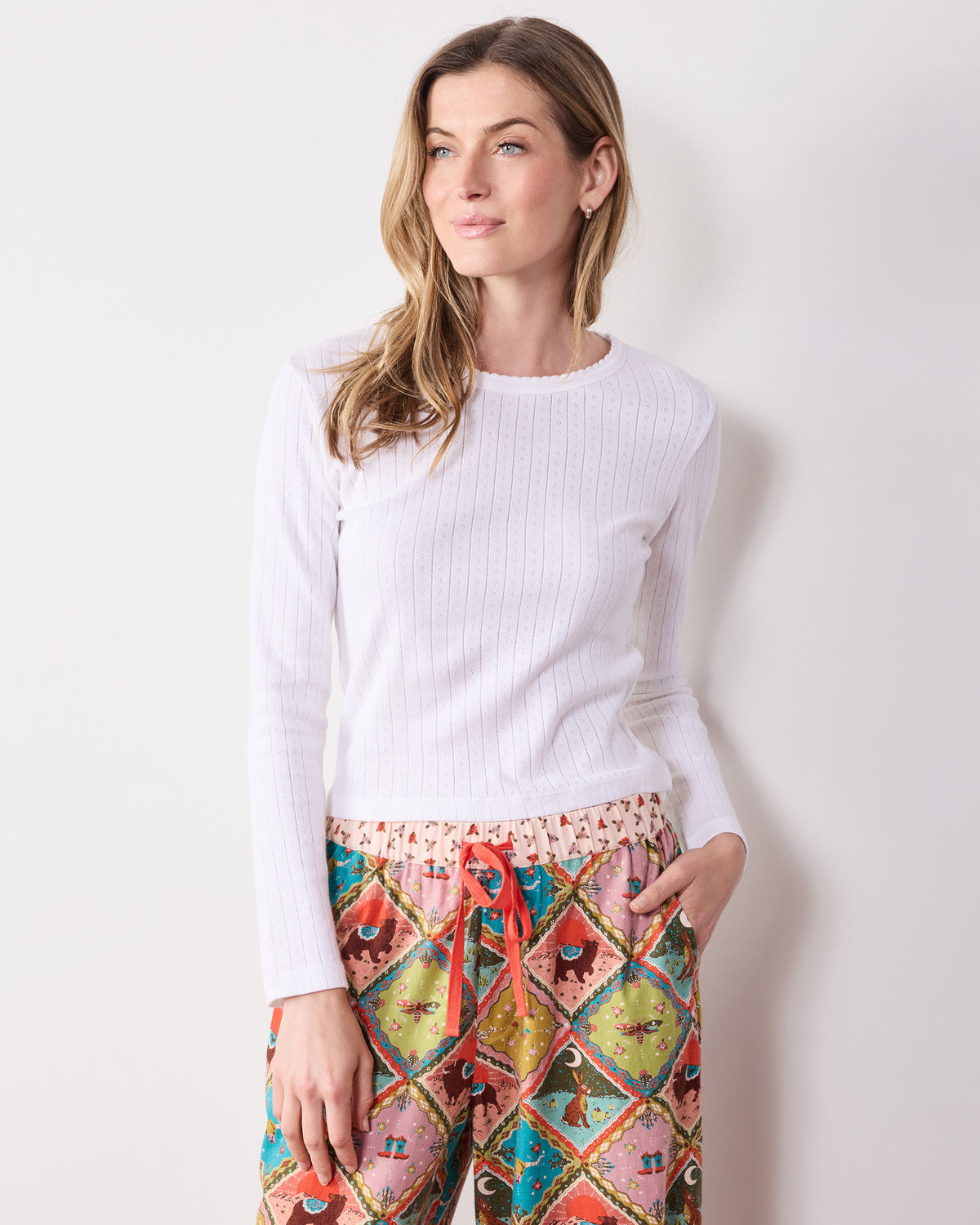 Cropped view of a person wearing Western Scenes patterned pants with an elastic drawstring waist and wide legs.