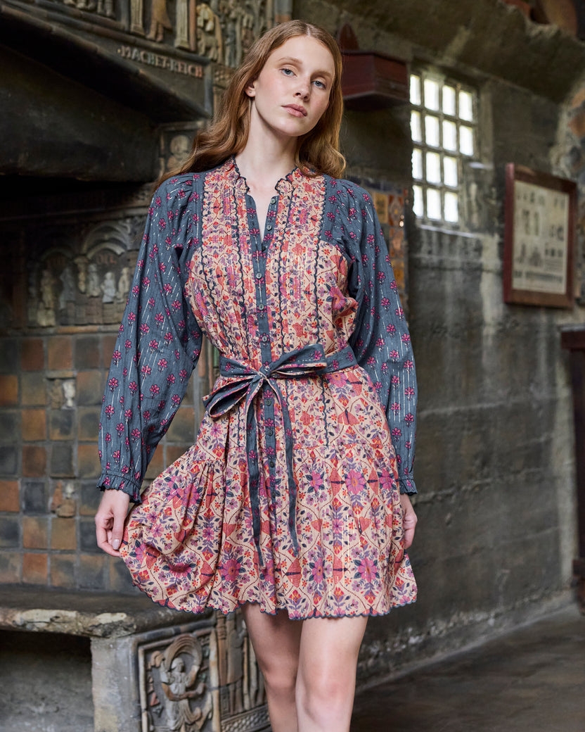 Front view of the Winged Tapestry Lauren dress with a tie belt, floral print, button placket, long sleeves, and scalloped skirt hem.