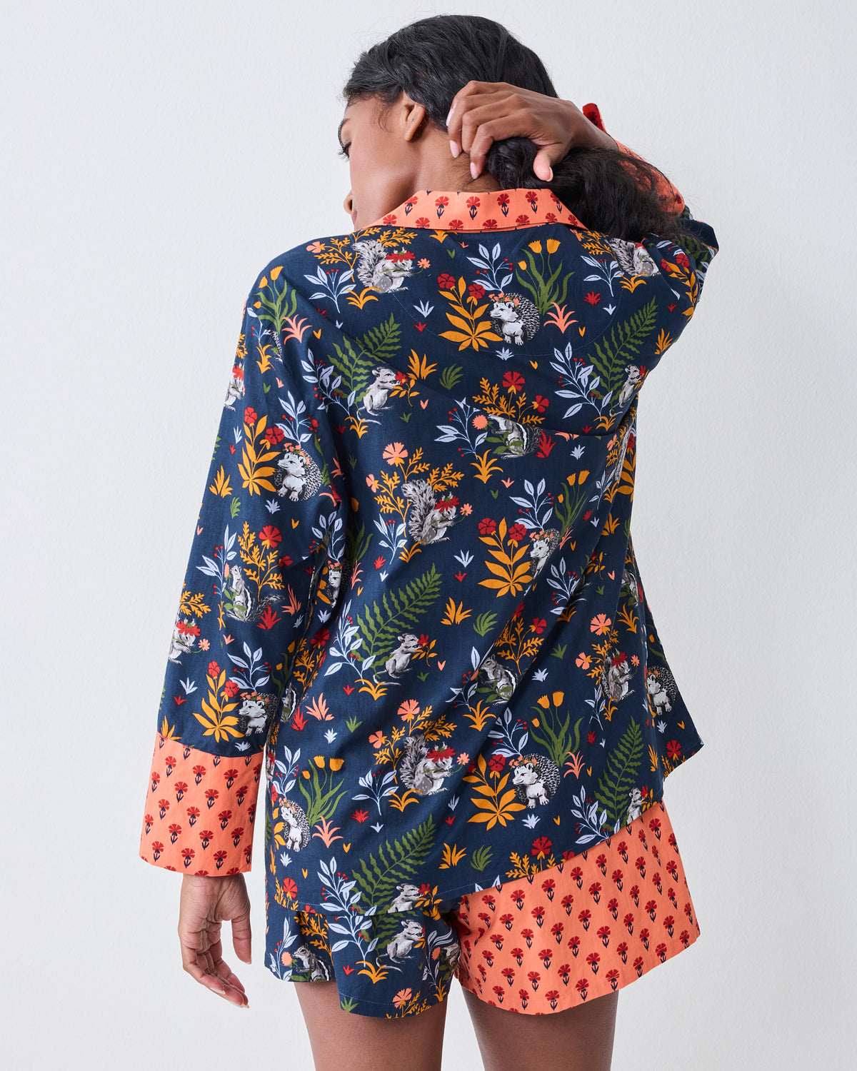 Back view of a person wearing the indigo Woodland Critters pajama top and coordinating shorts, showing the full-back print and contrasting trim.