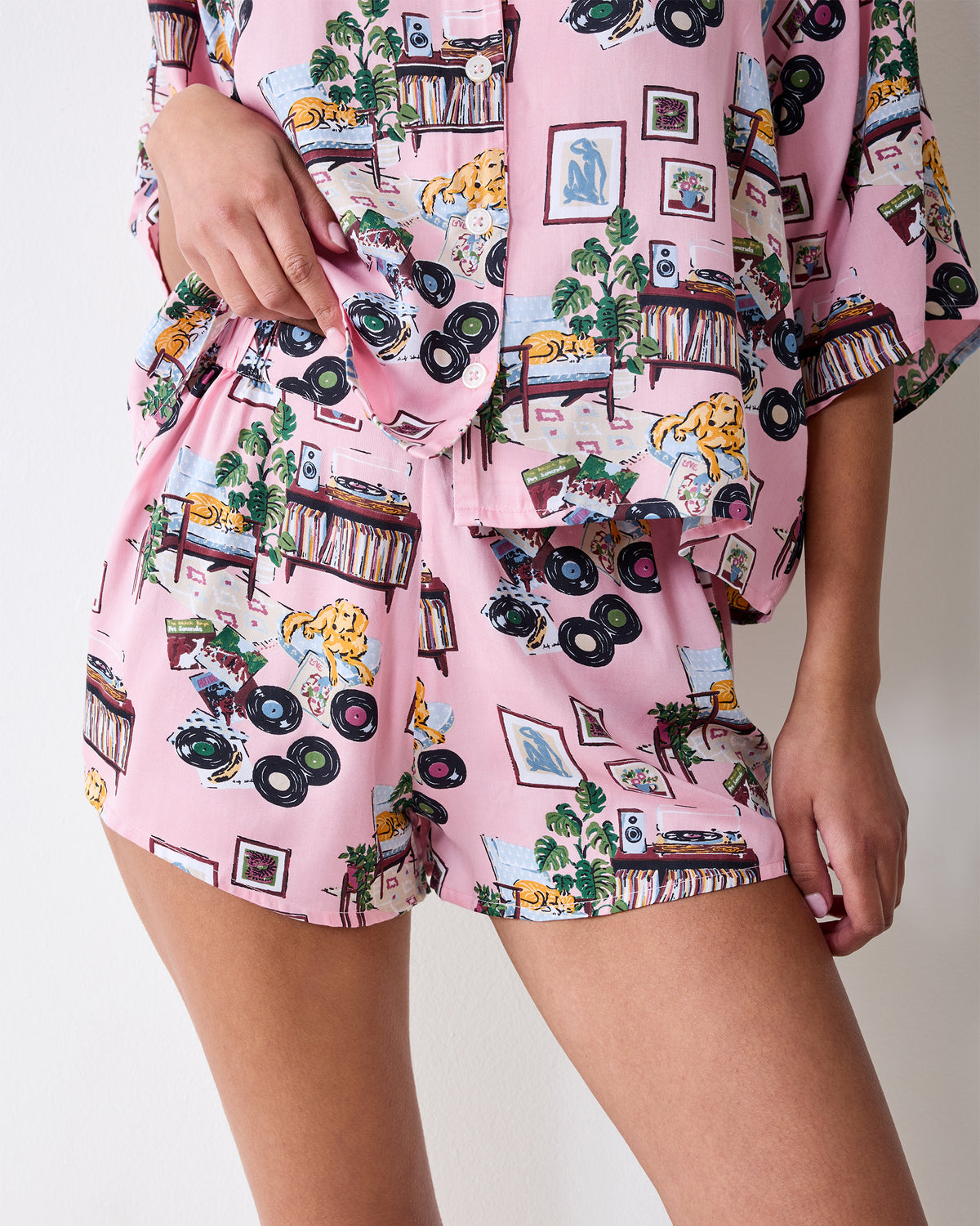 Close-up of the matching printed pajama shorts and the lower edge of the button-front top, showing a side pocket and elastic waistband.