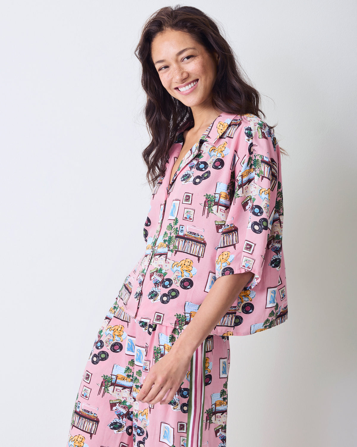 Side view of the pink printed Eco Satin Wildest Dreams pajama set with a cropped top and wide-leg pants.