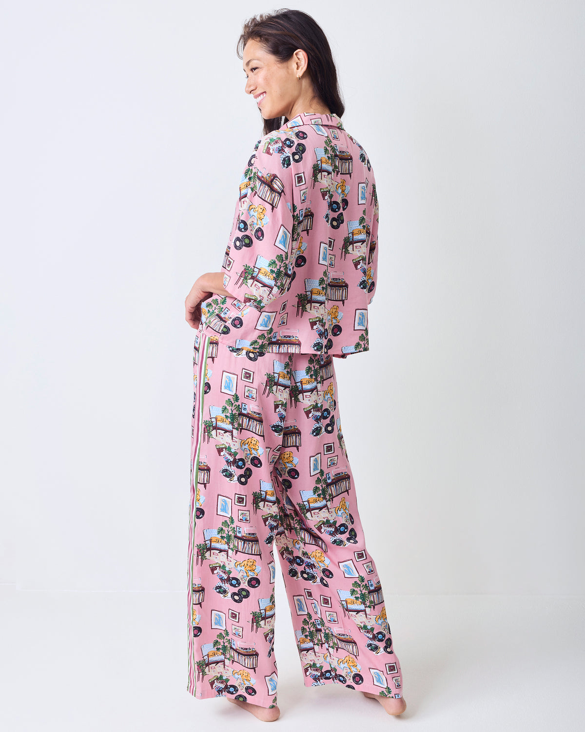 Back view of the petite pink Vinyl Collector pajama set with a cropped top, wide-leg pants, side stripe, and record-themed print.
