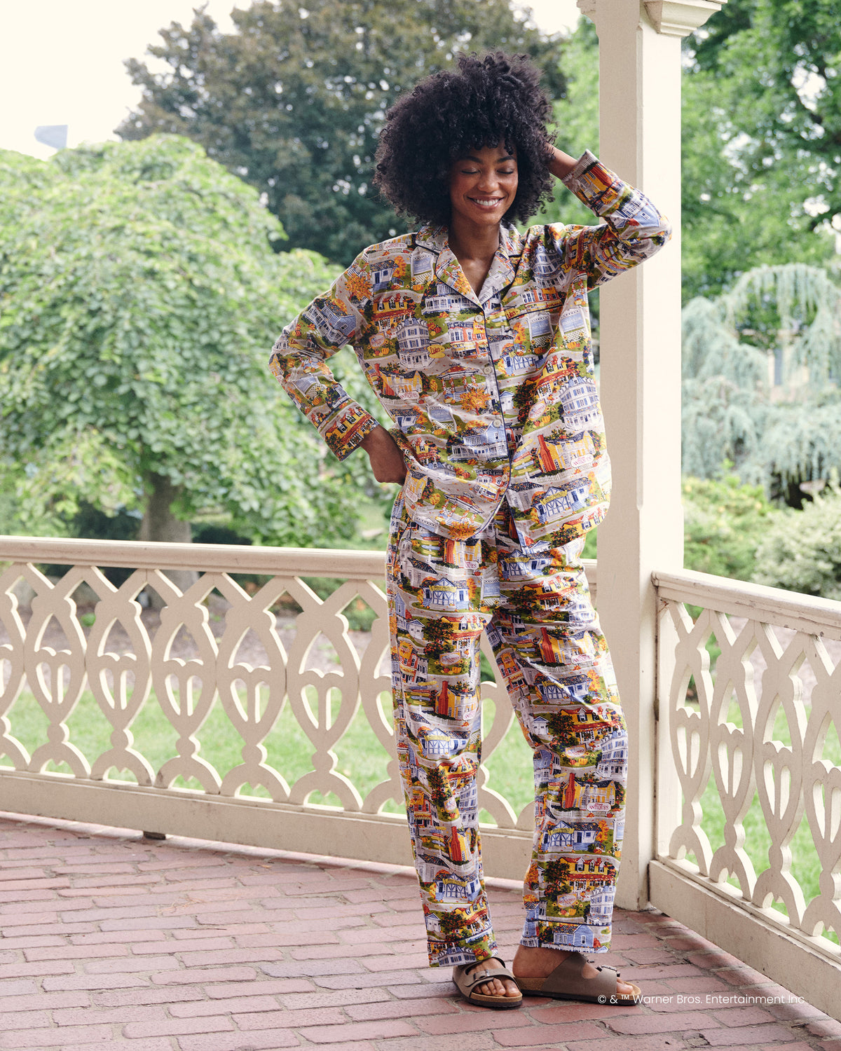 Full-length view of the Stars Hollow Harvest Festival tall long pajama set with a button-front top and matching pants on a porch.