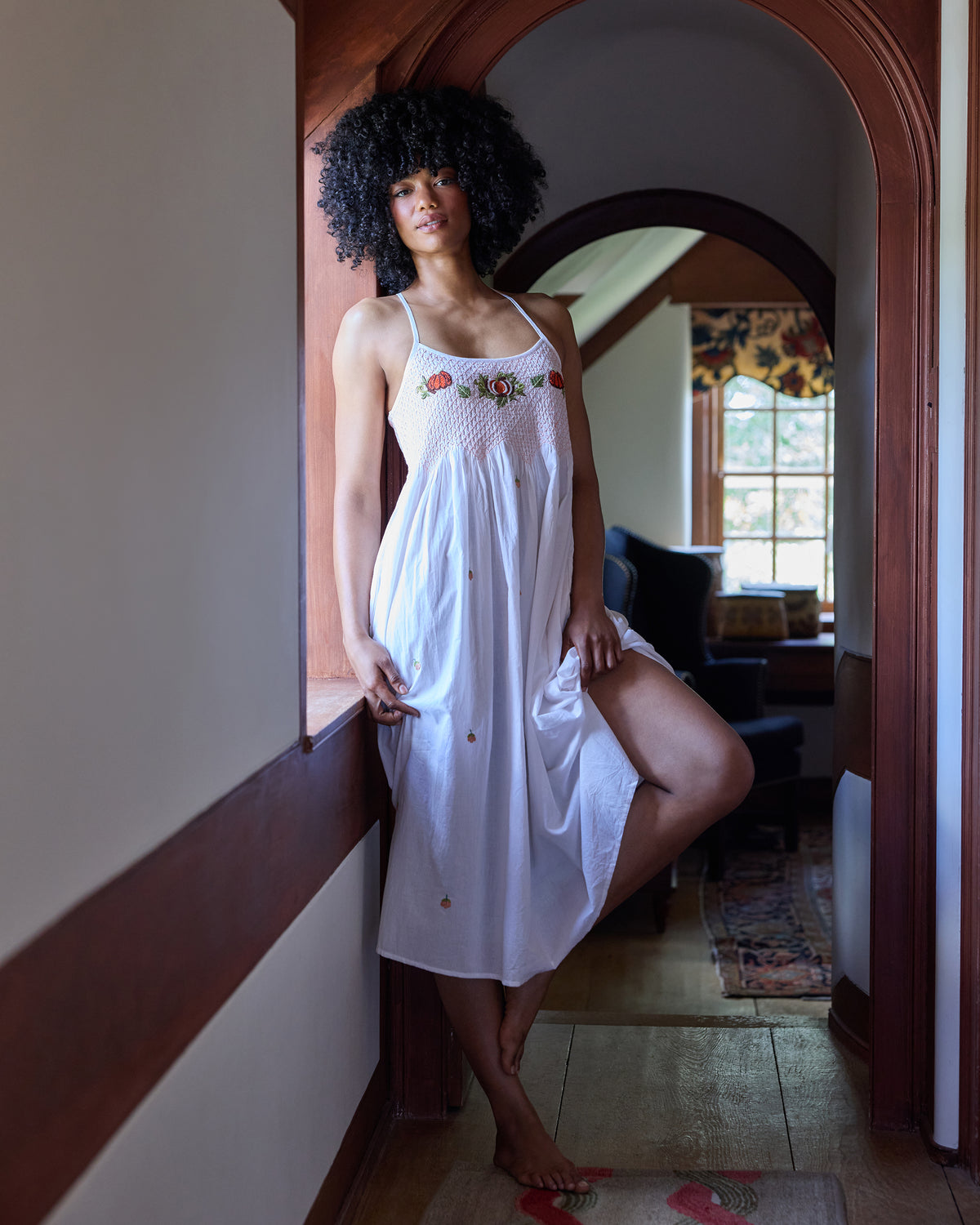 Front view of the embroidered pumpkin Naya nightie, showing the smocked bodice, floral pumpkin embroidery, and side pockets.