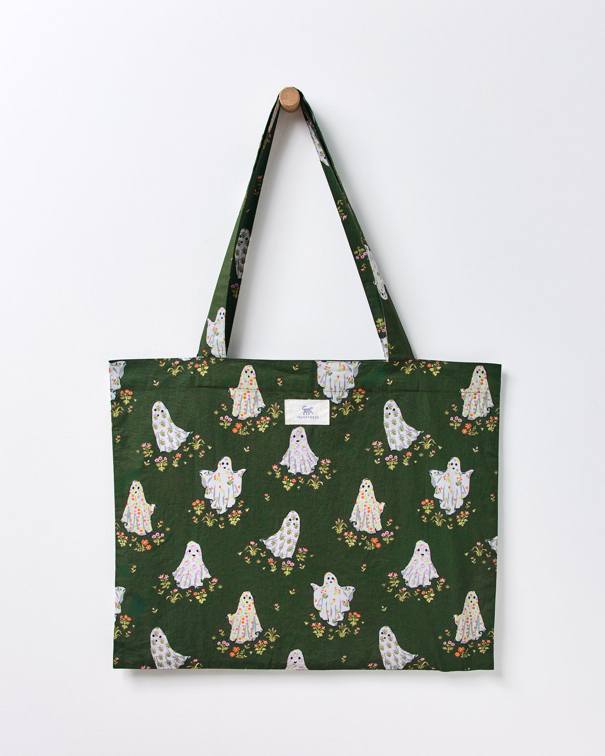 Ghost-print tote bag hanging from a wall, with long handles and a PRINTFRESH label.