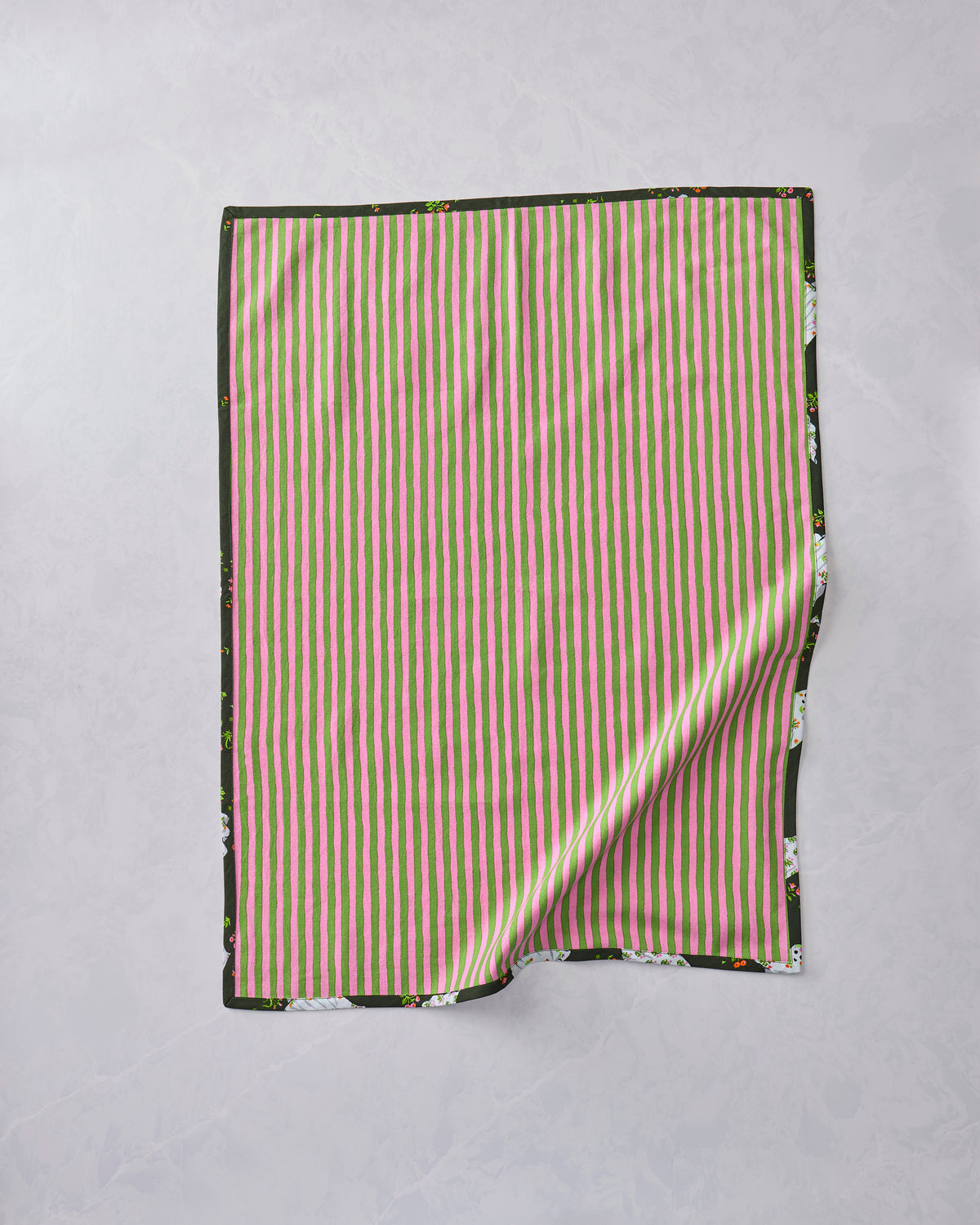 Tea towel laid flat to show its pink-and-green striped reverse side with a dark printed border.