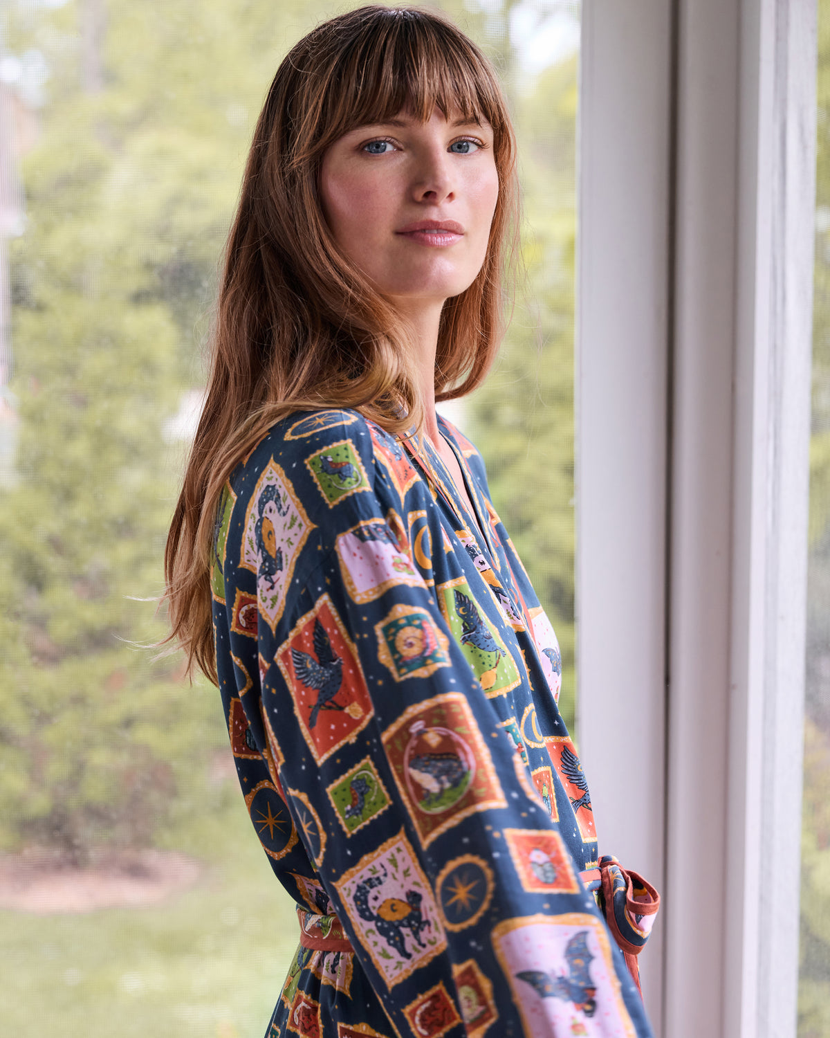 Side view of the Midnight Gallery patterned wrap robe, showing the sleeve and waist sash.