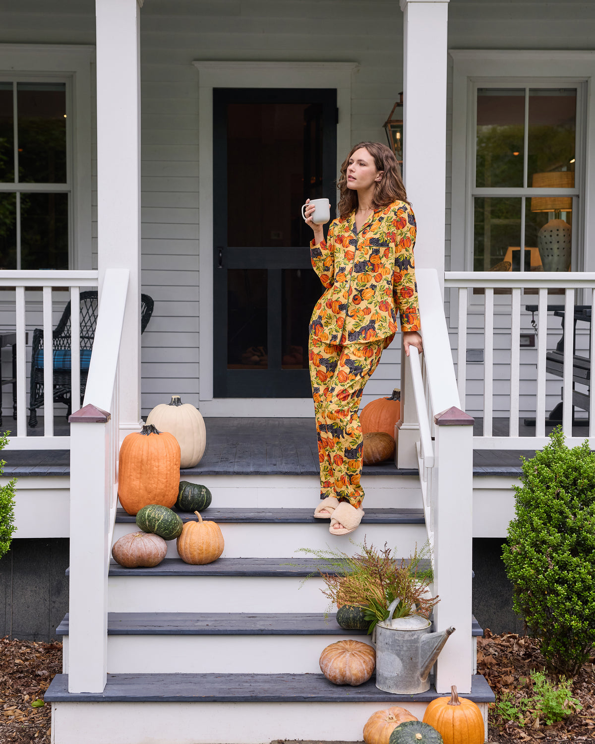 Front view of the Pumpkin Prowl long pajama set with long-sleeved button-front top, pants, pumpkin and black cat print, and pockets.