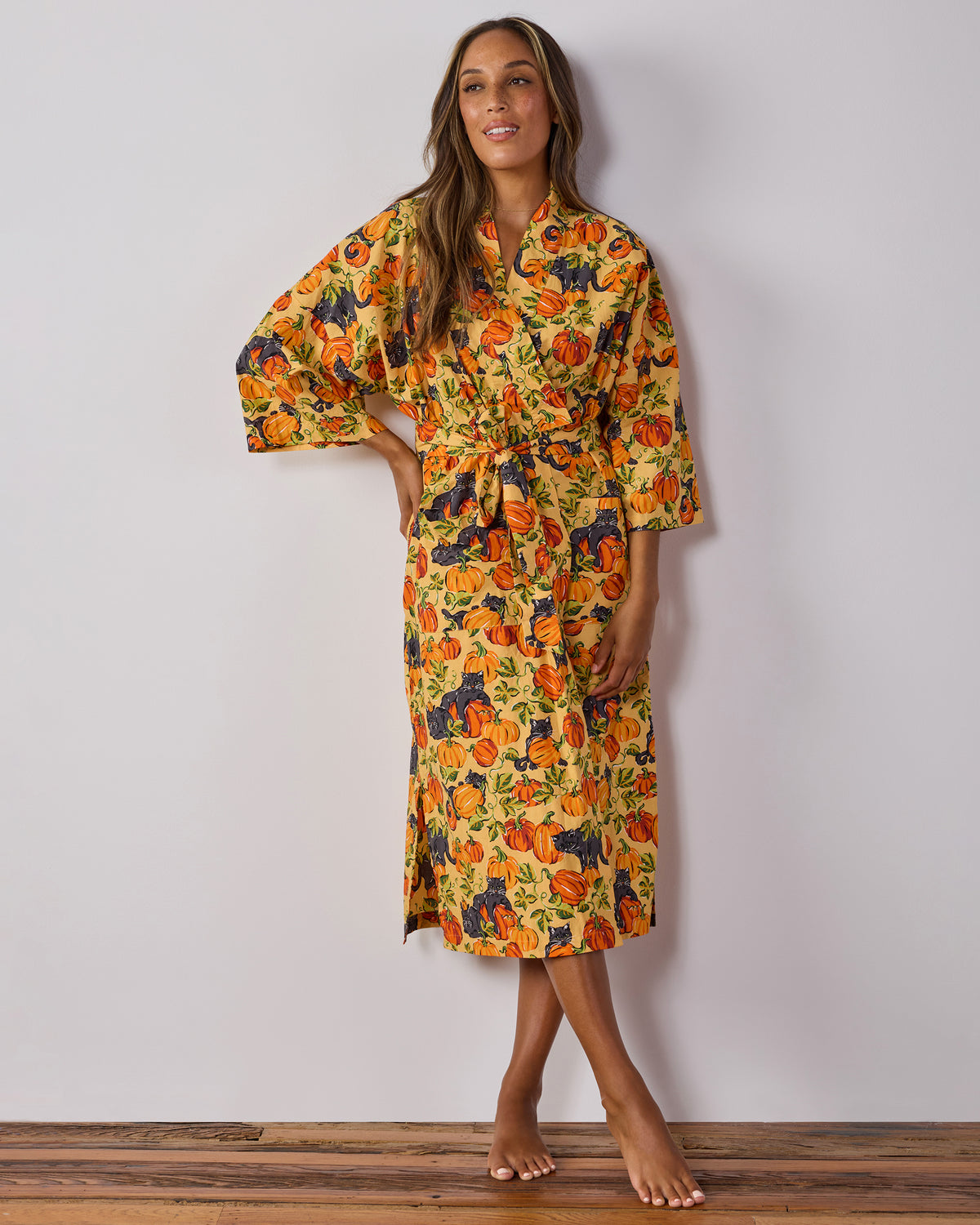 Full-length front view of a person wearing the Pumpkin Prowl long robe with a tied belt and pumpkin and black-cat print.