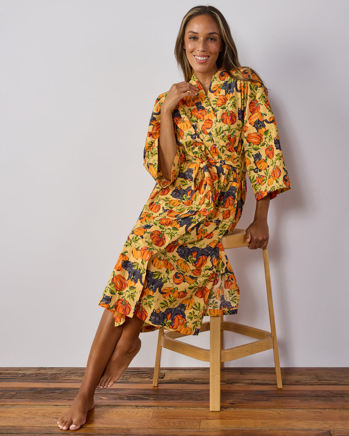 Front view of the Pumpkin Prowl salted caramel long robe, showing its pumpkin-and-black-cat print, wrap front, belt, and long sleeves.