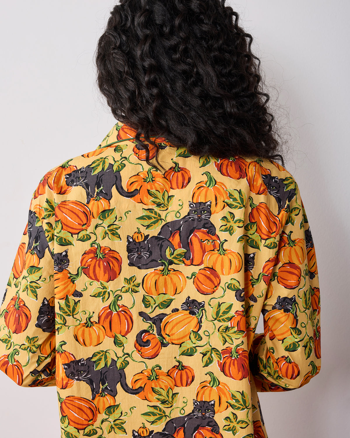 Back view of the pajama top showing the pumpkin and black cat print.