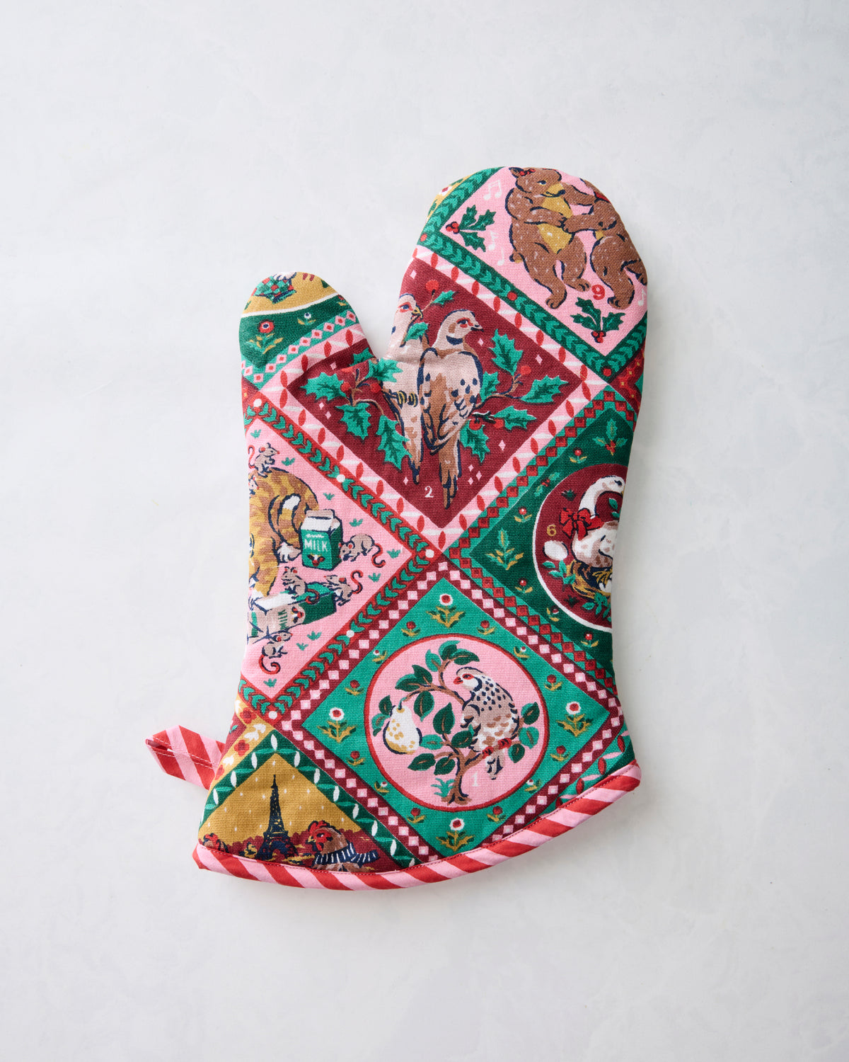 Christmas-themed oven mitt shown from the opposite angle, with illustrated animals, holiday scenes, and a hanging loop.