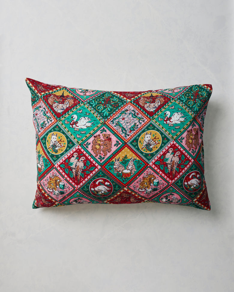 Rectangular pillowcase with a colorful repeating vintage holiday pattern of birds, animals, plants, and decorative borders.