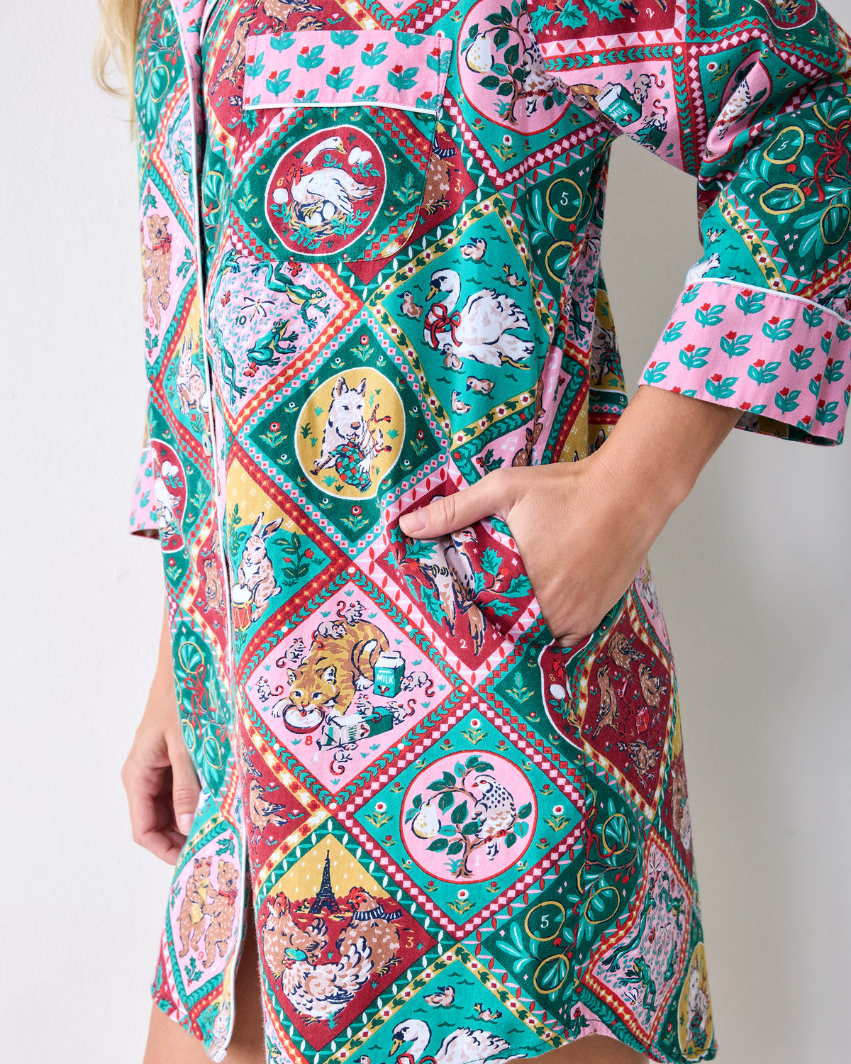 Side detail of a patterned sleep shirt showing its patch pocket, cuff, and curved hem.