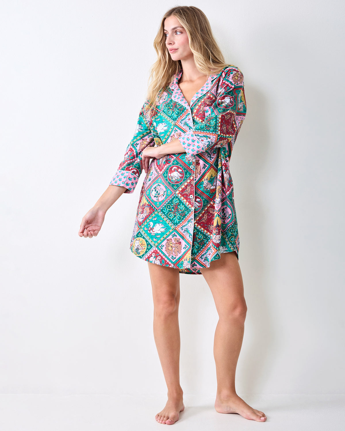 Full-length front view of a person wearing a patterned short sleep shirt with rolled cuffs.