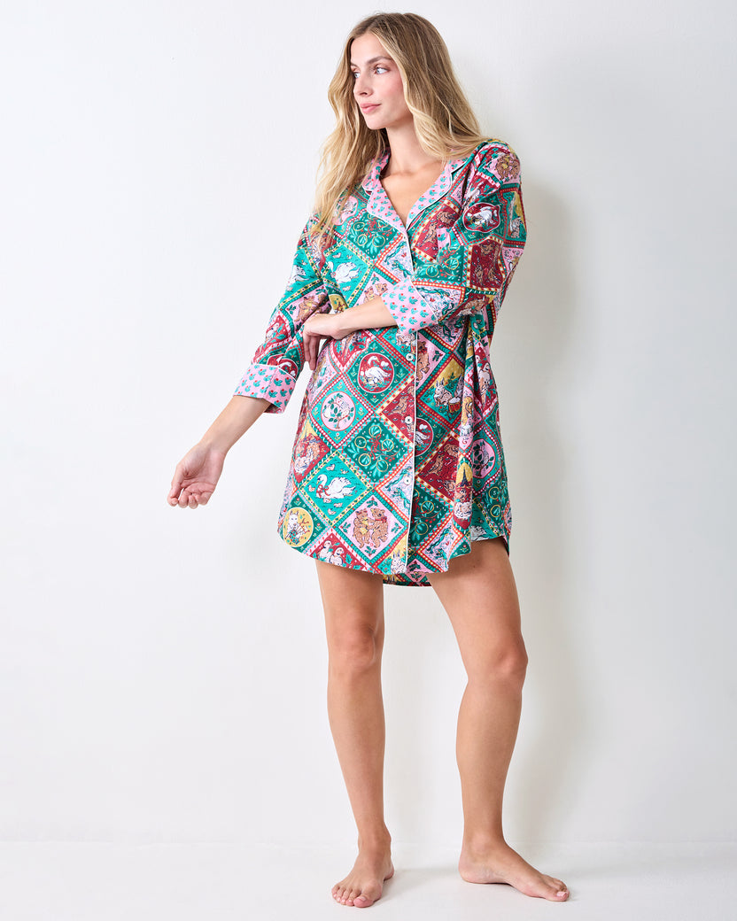 Full-length front view of a person wearing a patterned short sleep shirt with rolled cuffs.