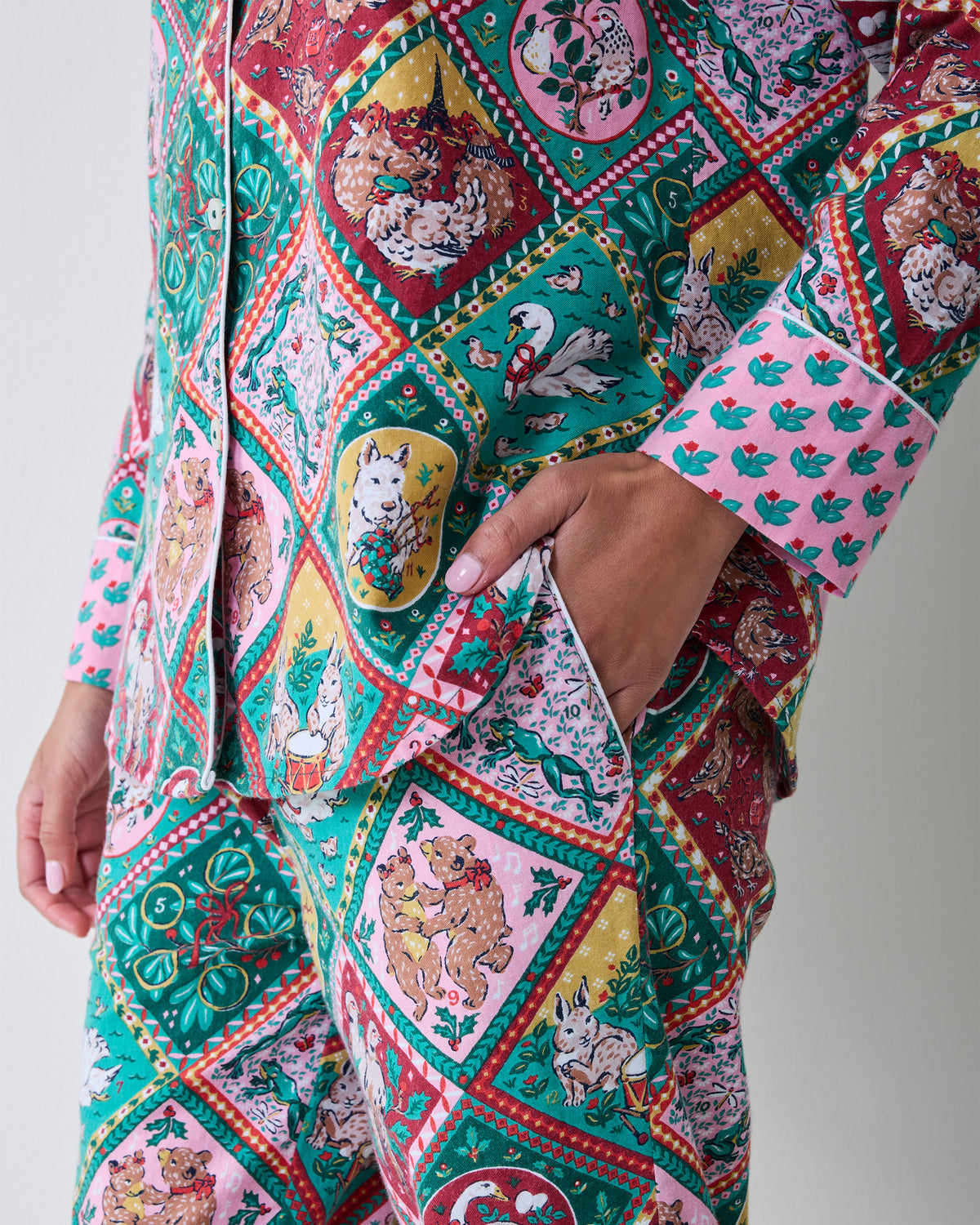 Close detail of the patterned long pajama set showing the button-front top, matching pants, and side pocket.