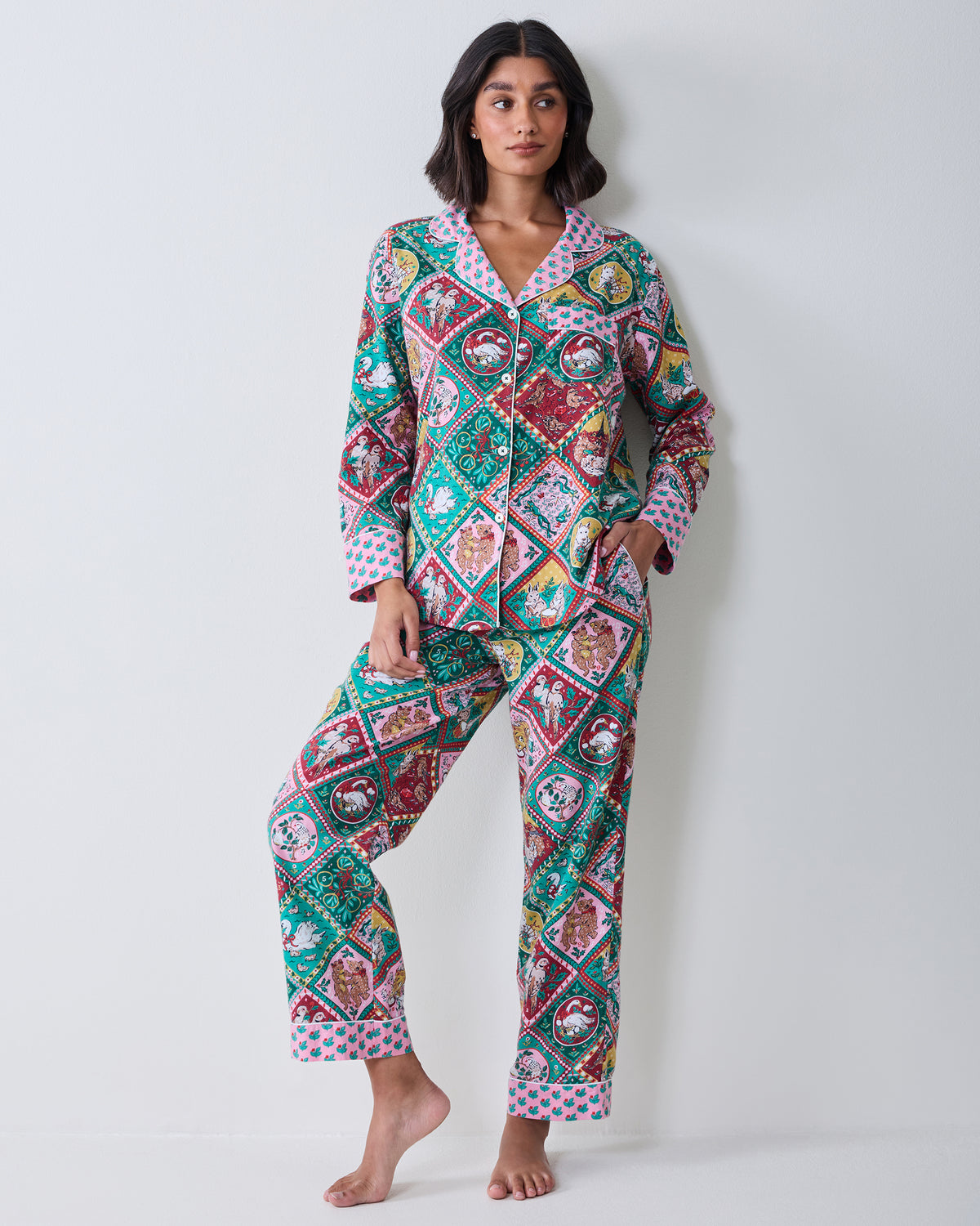 Full-length front view of a long-sleeved button-front pajama top and matching straight-leg pants with pink floral trim.