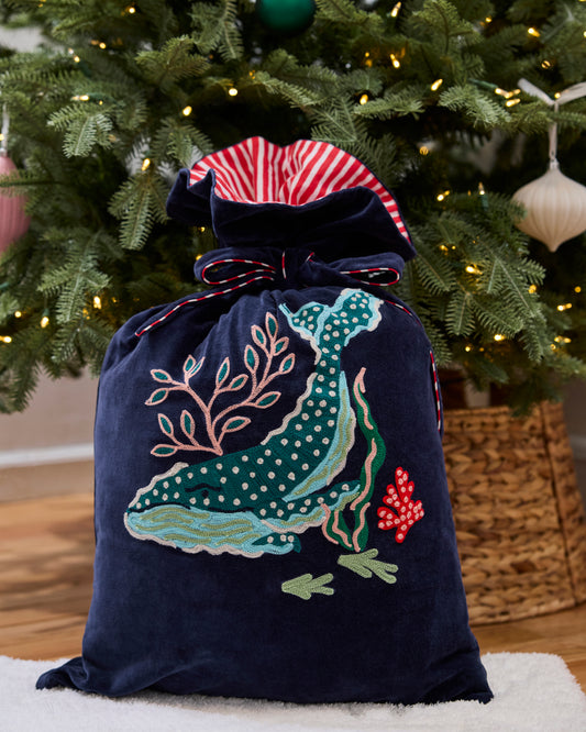 Blue Chill embroidered gift sack with a sealife motif and drawstring closure in front of a decorated Christmas tree